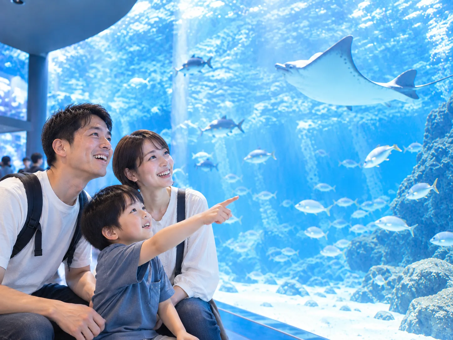 水族館でエイを見上げる家族